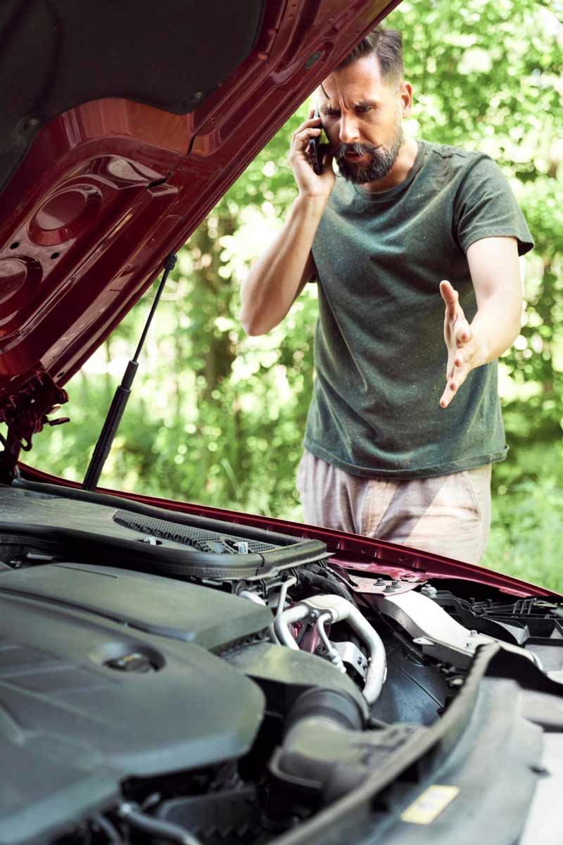 Junger Mann prüft Getriebeschaden bei Schrottauto Ankauf Uelzen